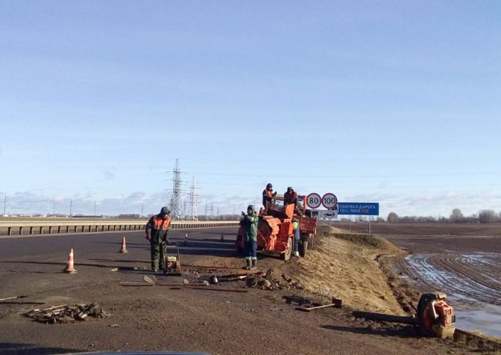 На дорожной развязке возле Лучников дорожники заделывают яму,